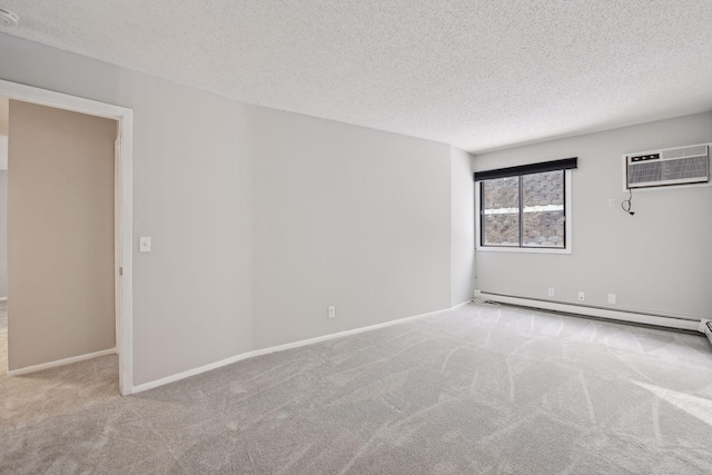 spare room with baseboard heating, baseboards, a textured ceiling, a wall unit AC, and carpet