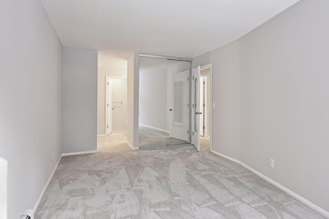 unfurnished room featuring baseboards, carpet, and a baseboard heating unit
