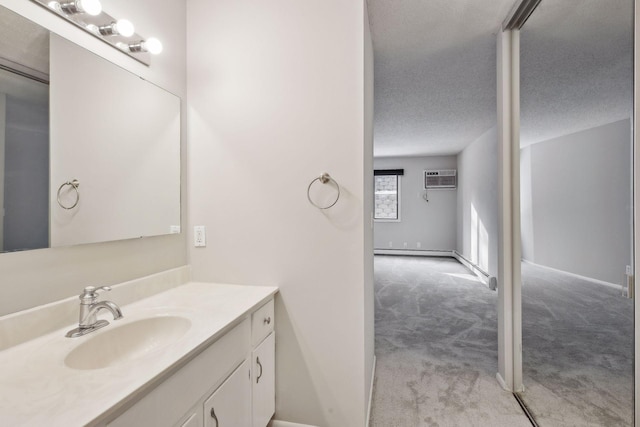 bathroom with vanity, an AC wall unit, and a textured ceiling