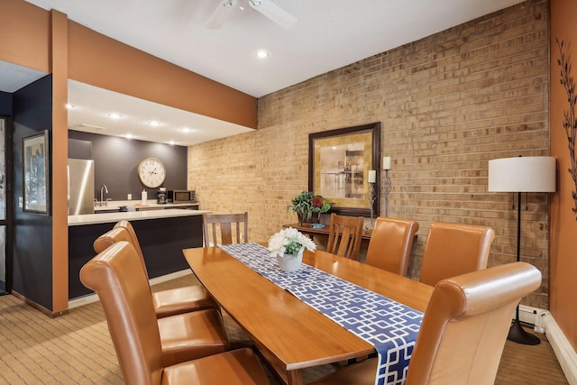 dining area featuring ceiling fan, recessed lighting, brick wall, and baseboards