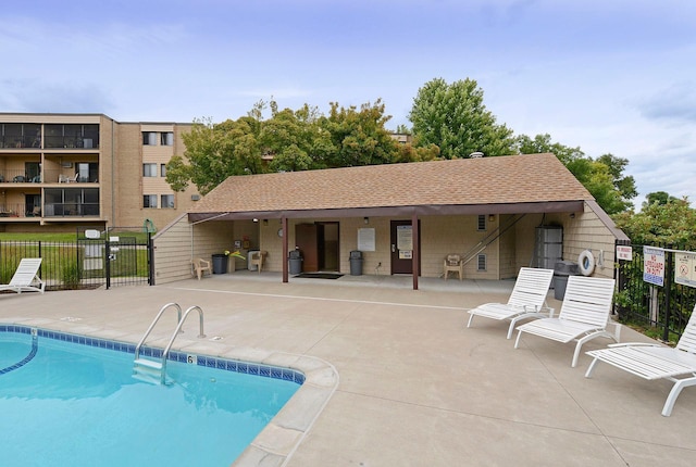 community pool with a patio and fence