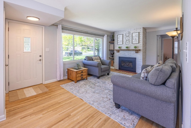 living area with wood finished floors, a fireplace, and baseboards