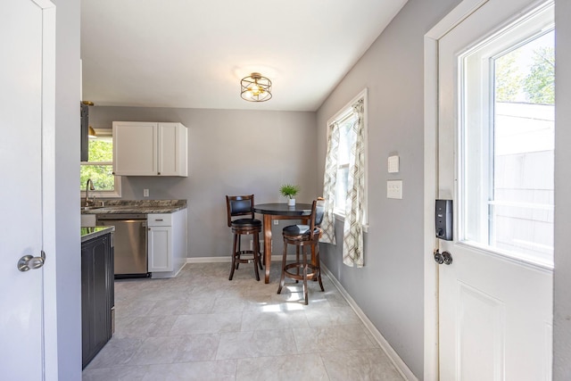 dining space with baseboards and light tile patterned floors