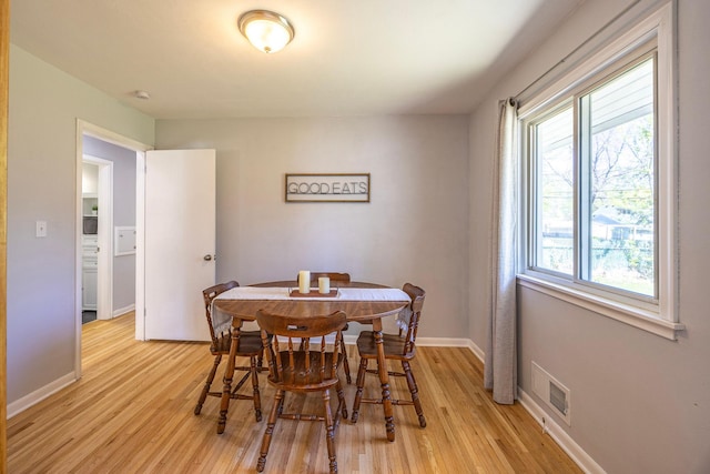 dining area with light wood-style flooring and baseboards