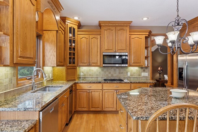 268 Saint Andrews Dr, Hudson, WI 54016 - kitchen featuring stainless steel appliances, a sink, a chandelier, brown cabinetry, and recessed lighting