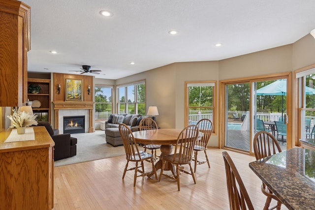 268 Saint Andrews Dr, Hudson, WI 54016 - dining area featuring a glass covered fireplace, plenty of natural light, light wood-style flooring, and recessed lighting
