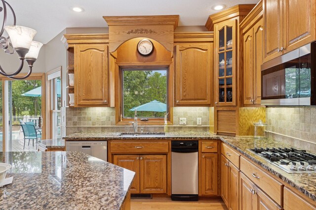 268 Saint Andrews Dr, Hudson, WI 54016 - kitchen featuring stainless steel appliances, dark stone counters, a chandelier, glass insert cabinets, and light wood-style floors