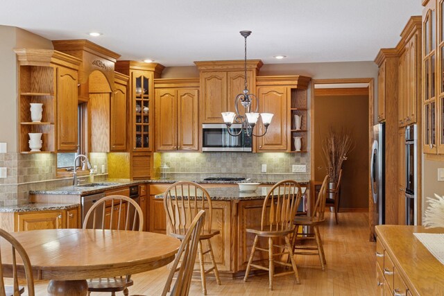 268 Saint Andrews Dr, Hudson, WI 54016 - kitchen with appliances with stainless steel finishes, open shelves, brown cabinets, a chandelier, and light wood finished floors