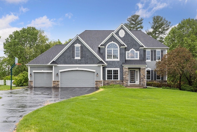 268 Saint Andrews Dr, Hudson, WI 54016 - view of front of house featuring stone siding, driveway, a front lawn, an attached garage, and a shingled roof