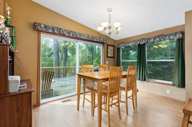 969 Dosh Rd, Fort Ripley, MN 56449 - dining area with lofted ceiling, an inviting chandelier, baseboards, light wood-style floors, and visible vents