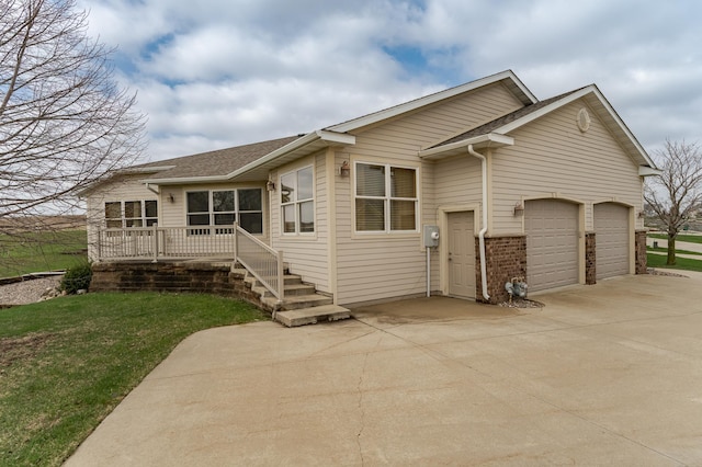 view of front of home with a shingled roof, a front lawn, concrete driveway, brick siding, and a garage