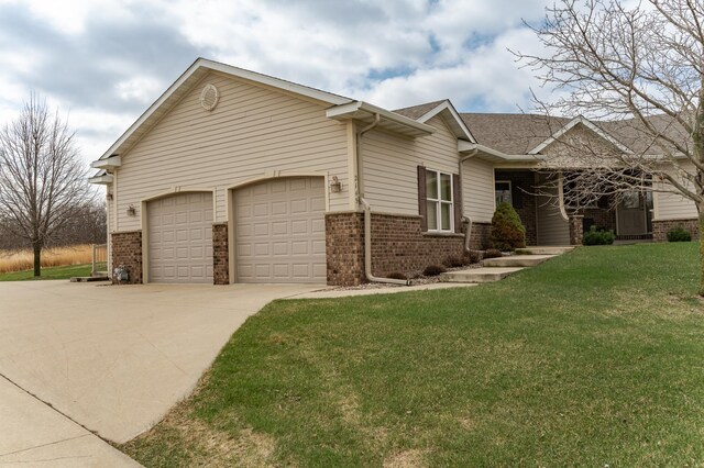 ranch-style house with brick siding, an attached garage, driveway, and a front yard