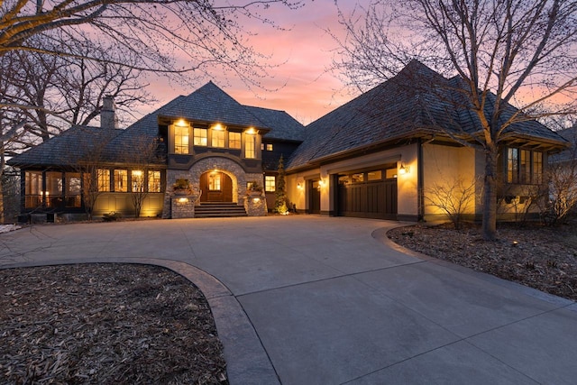 425 Carpenters Pt, Wayzata, MN 55391 - view of front of house with curved driveway, a garage, a chimney, and stone siding