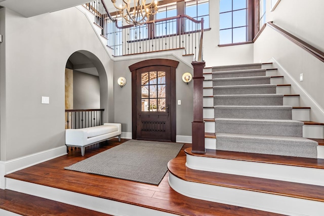 425 Carpenters Pt, Wayzata, MN 55391 - foyer entrance featuring stairs, a high ceiling, baseboards, a chandelier, and wood finished floors