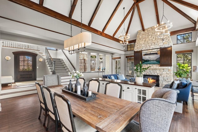 425 Carpenters Pt, Wayzata, MN 55391 - dining area with high vaulted ceiling, stairs, a chandelier, beam ceiling, and a stone fireplace