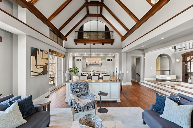 425 Carpenters Pt, Wayzata, MN 55391 - living room featuring arched walkways, high vaulted ceiling, dark wood-type flooring, baseboards, and beamed ceiling