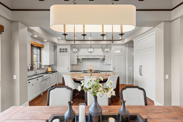 425 Carpenters Pt, Wayzata, MN 55391 - kitchen with dark wood finished floors, a sink, decorative backsplash, an island with sink, and recessed lighting