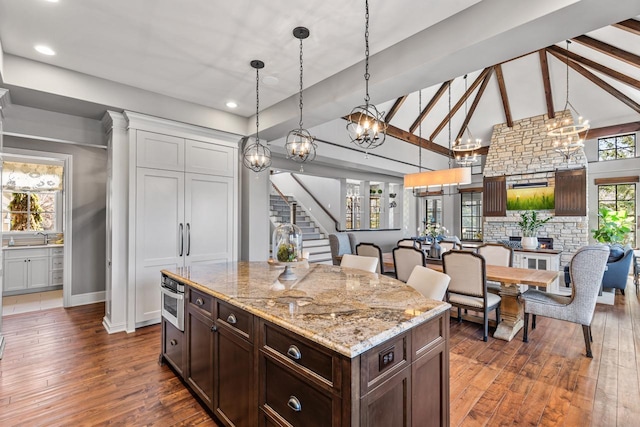 425 Carpenters Pt, Wayzata, MN 55391 - kitchen with dark brown cabinetry, dark wood finished floors, hanging light fixtures, a chandelier, and high vaulted ceiling