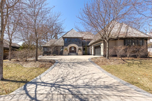 425 Carpenters Pt, Wayzata, MN 55391 - french country style house with driveway, an attached garage, a front lawn, stone siding, and stucco siding