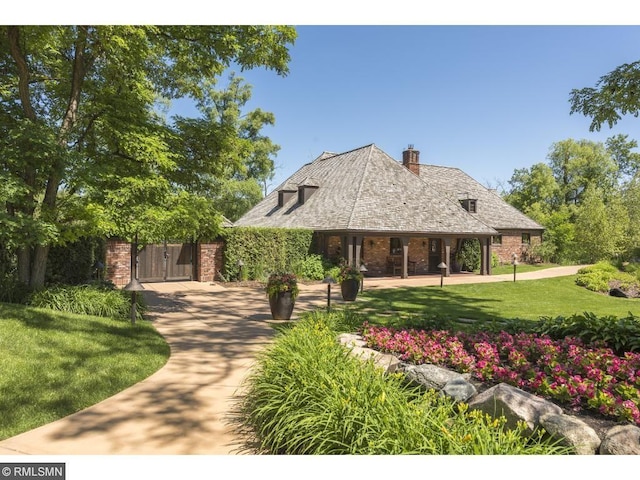 425 Carpenters Pt, Wayzata, MN 55391 - view of front of property featuring a front yard, a chimney, and brick siding