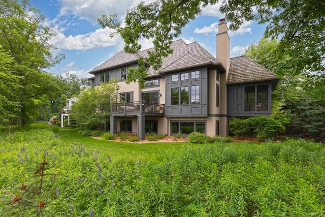 425 Carpenters Pt, Wayzata, MN 55391 - back of house with stucco siding, a chimney, and a wooden deck