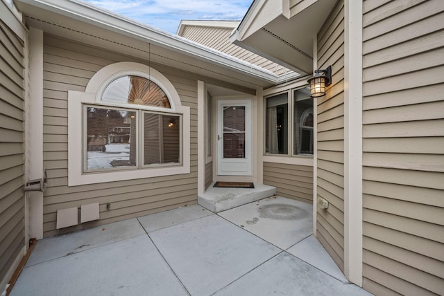 view of exterior entry with a patio area
