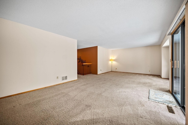unfurnished living room featuring visible vents, baseboards, and carpet flooring