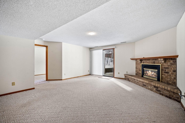 unfurnished living room with a fireplace, carpet floors, a textured ceiling, and baseboards