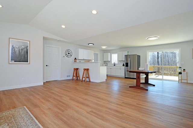 14113 260th St, Dailey Twp, MN 56353 - unfurnished living room with light wood-style flooring, lofted ceiling, baseboards, recessed lighting, and a sink
