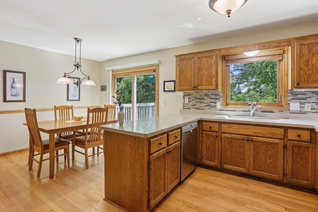 8671 Pheasant Run Rd, Woodbury, MN 55125 - kitchen with stainless steel dishwasher, a peninsula, brown cabinets, decorative backsplash, and light countertops
