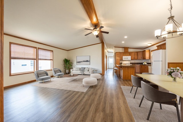 living area with baseboards, lofted ceiling with beams, crown molding, ceiling fan with notable chandelier, and wood finished floors