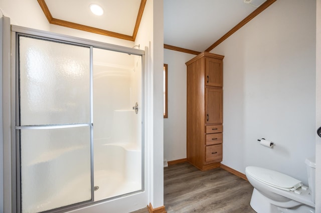 full bathroom with baseboards, ornamental molding, a stall shower, toilet, and wood finished floors