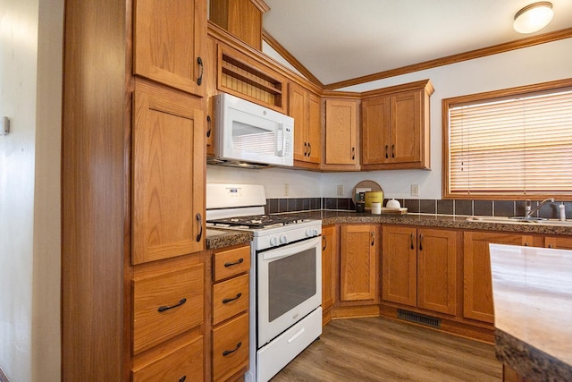 kitchen with visible vents, a sink, ornamental molding, white appliances, and brown cabinets