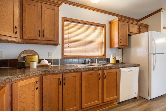 kitchen featuring white appliances, brown cabinets, and a sink