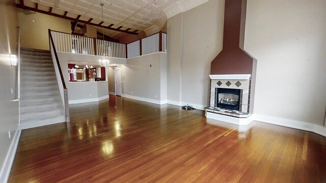 unfurnished living room featuring baseboards, wood finished floors, and stairway