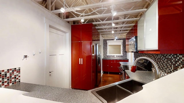 kitchen with backsplash, stainless steel appliances, and a sink