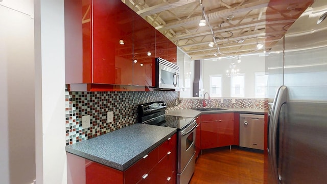 kitchen featuring dark wood-style flooring, appliances with stainless steel finishes, decorative backsplash, and a sink