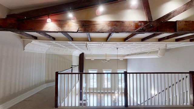 hallway with baseboards and beam ceiling