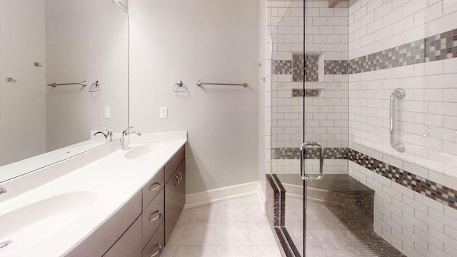 bathroom featuring tile patterned floors, a sink, double vanity, and a stall shower