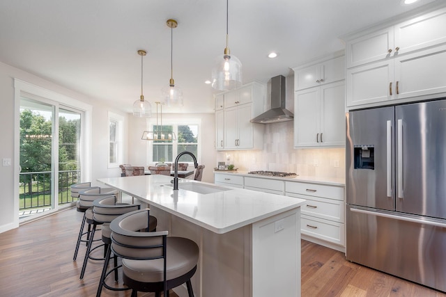 1005 Applewood Ct, Mankato, MN 56001 - kitchen with stainless steel appliances, decorative backsplash, a sink, a kitchen island with sink, and wall chimney exhaust hood
