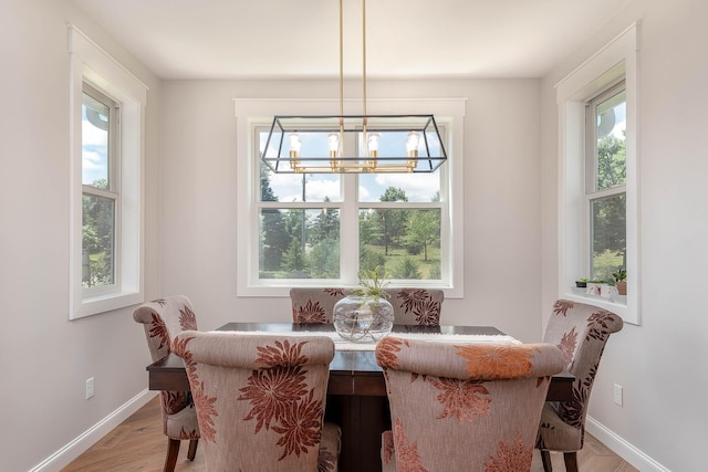 1005 Applewood Ct, Mankato, MN 56001 - dining space with baseboards, a notable chandelier, light wood-style flooring, and a healthy amount of sunlight