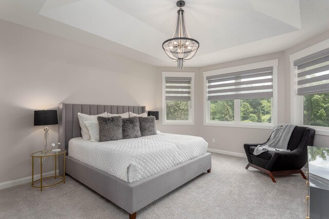 1005 Applewood Ct, Mankato, MN 56001 - carpeted bedroom with a raised ceiling, baseboards, and a chandelier
