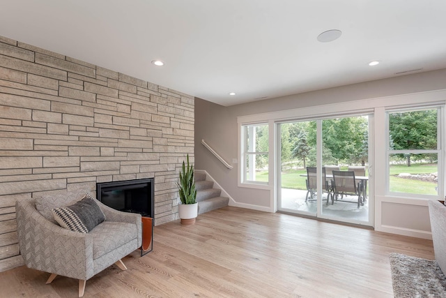 1005 Applewood Ct, Mankato, MN 56001 - living area featuring a stone fireplace, stairs, light wood-style flooring, and recessed lighting
