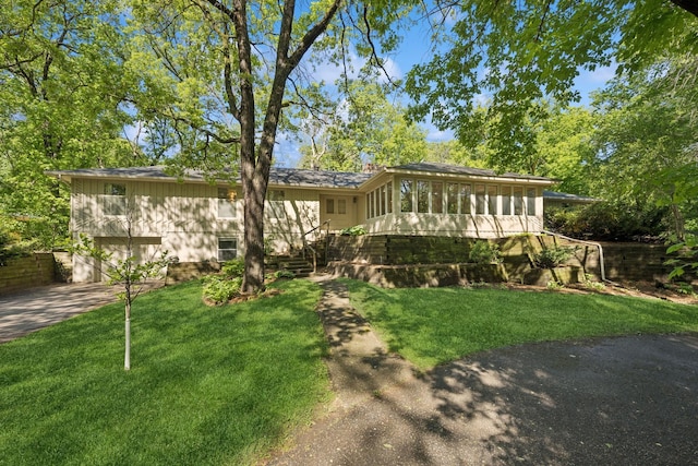 13907 Mcginty Rd E, Minnetonka, MN 55305 - view of front of property featuring a front lawn, concrete driveway, an attached garage, and a sunroom