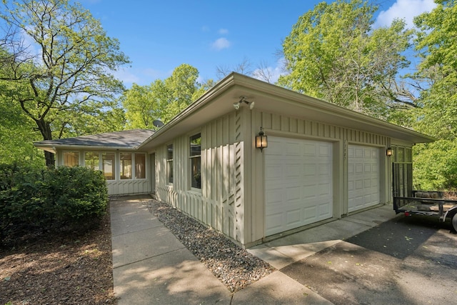 13907 Mcginty Rd E, Minnetonka, MN 55305 - view of side of home with a garage, board and batten siding, and driveway