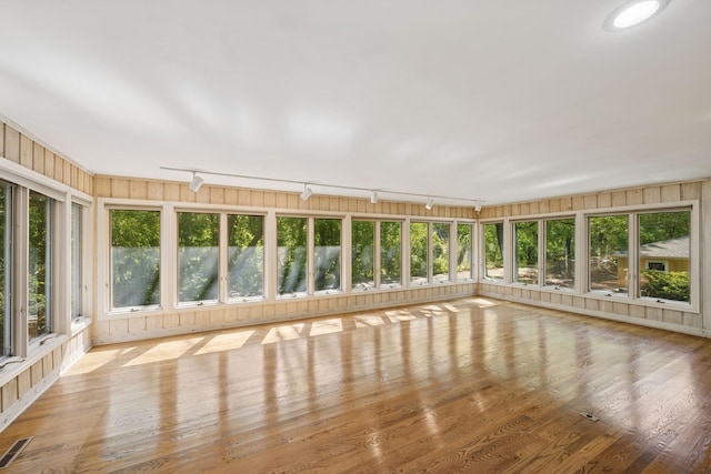 13907 Mcginty Rd E, Minnetonka, MN 55305 - unfurnished sunroom with rail lighting, plenty of natural light, and wood finished floors
