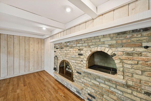 13907 Mcginty Rd E, Minnetonka, MN 55305 - unfurnished living room with beamed ceiling, a fireplace, wood finished floors, and wood walls
