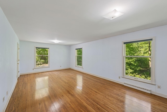 13907 Mcginty Rd E, Minnetonka, MN 55305 - empty room featuring a baseboard radiator, light wood-style flooring, and baseboards