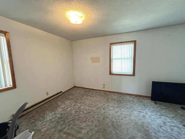 carpeted empty room featuring a textured ceiling and baseboards