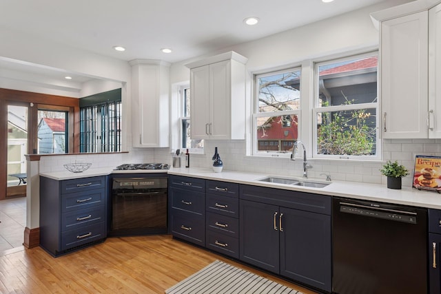 kitchen featuring white cabinetry, dishwasher, light countertops, and a sink